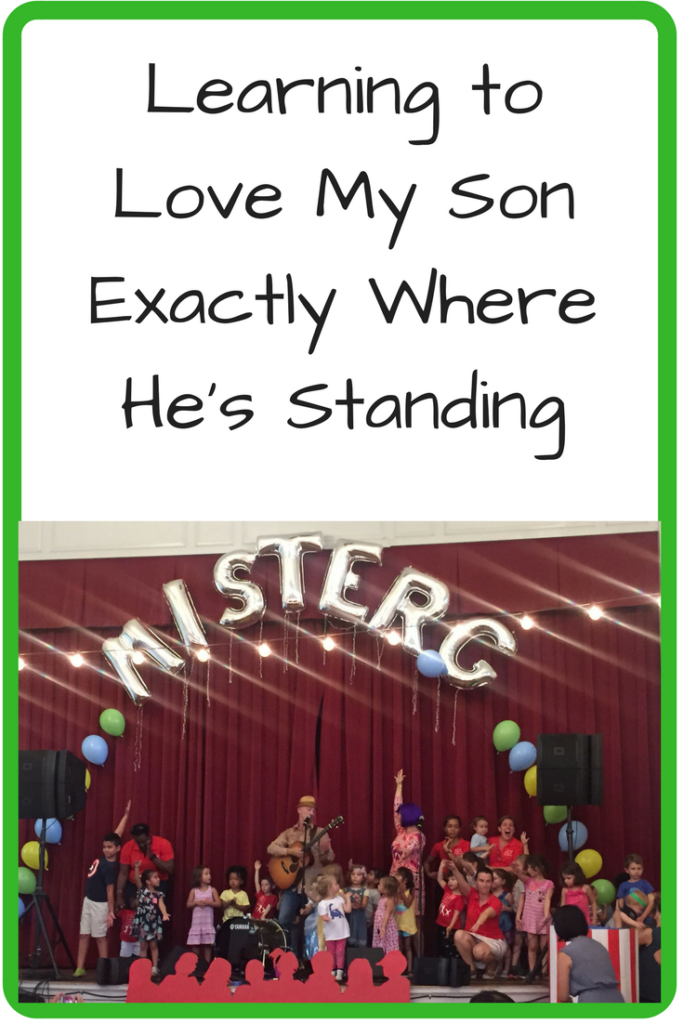 Learning to Love My Son Exactly Where He's Standing. What happens when your music loving kid doesn't want to go up front to a concert? (Photo: Kids standing on stage with a musician with the words "Mister G" in balloon letters above them.)