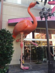 Photo of giant fake flamingo with white mom and kid posing in front of it