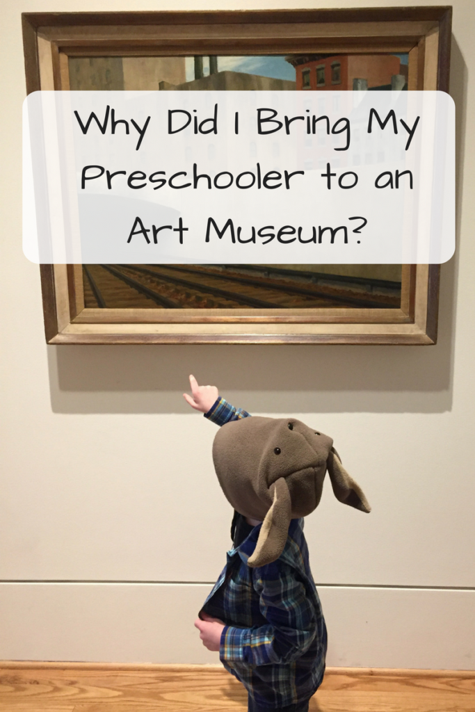 Why Did I Bring My Preschooler to an Art Museum? (Photo of kid in a bunny hat and flannel shirt pointing to a painting of railroad tracks)