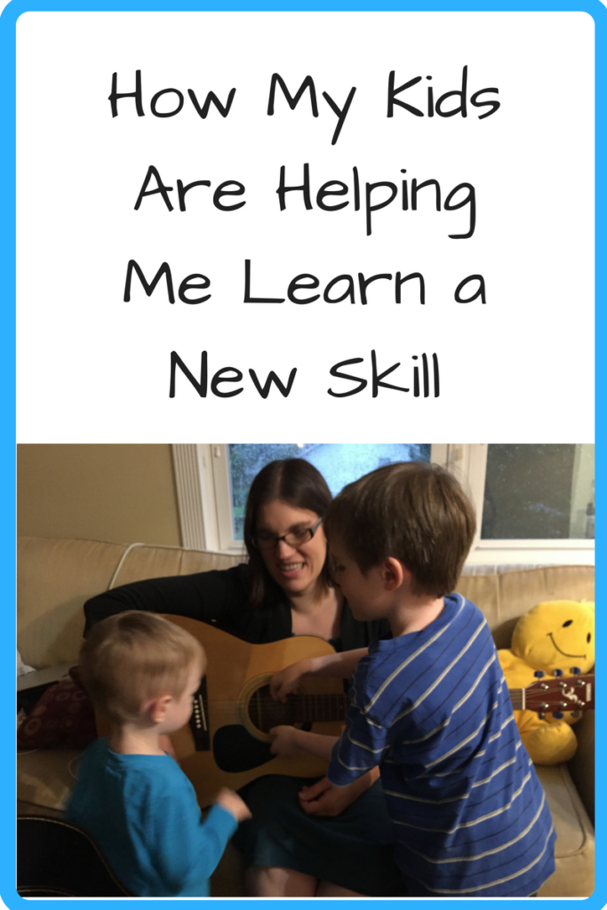 How My Kids Are Helping Me Learn a New Skill (Photo: White woman holding an acoustic guitar with two kids in front of her)