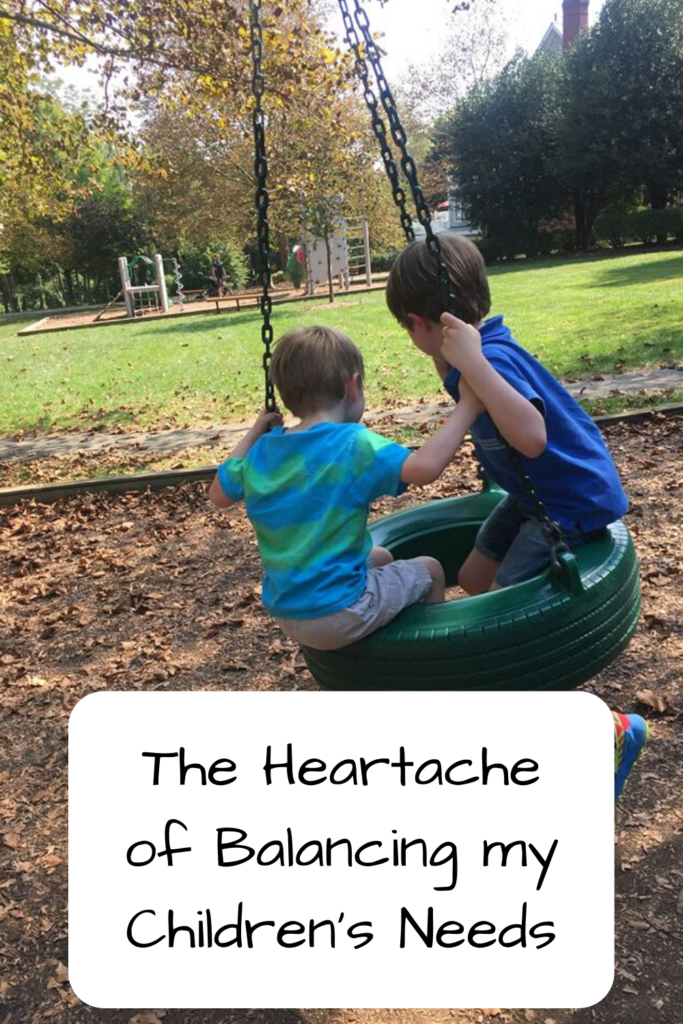 Text: The Heartache of Balancing My Children's Needs; Photo: Two white boys swinging on a green tire swing