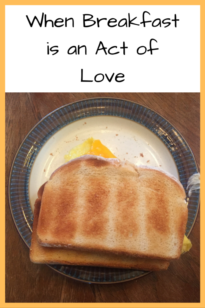 Text: When Breakfast is an Act of Love Photo: Egg sandwich with cheese on white bread on a purple plate on a wood table