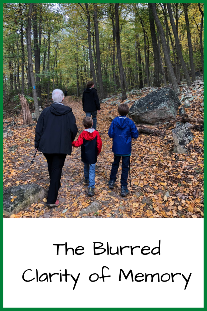 Photo of two children and a woman in hiking clothes hiking down a trail covered in leaves; text: The Blurred Clarity of Memory