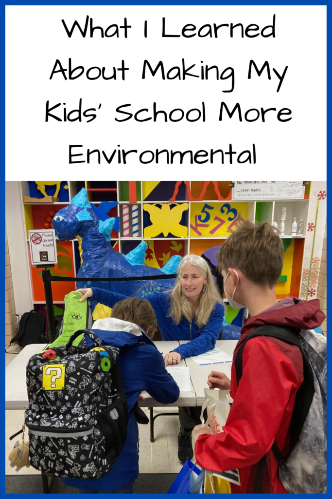 What I Learned About Making My Kids' School More Environmental; photo of kids standing in front of a desk with a teacher behind the desk and a paper-mache dragon behind her