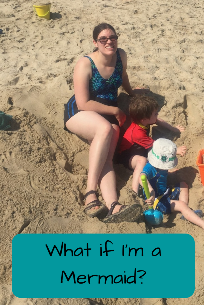 What if I'm a Mermaid? Photo of a white woman in a bathing suit sitting in the sand with two white children in bathing suits