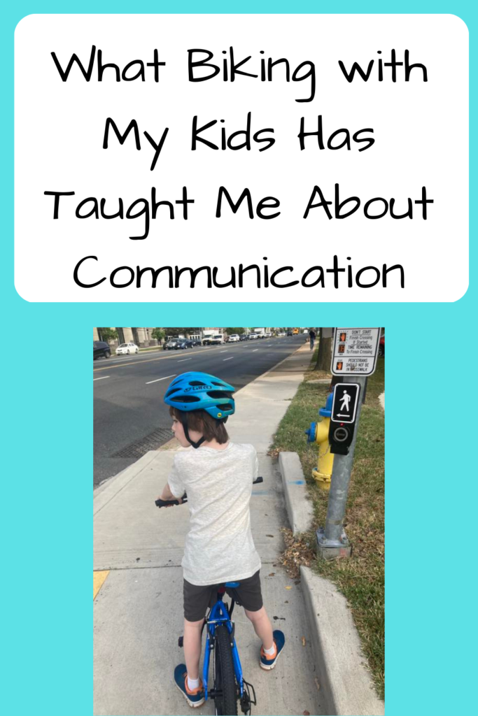 What Biking with my Kids Has Taught Me About Communication; photo of my kid (a white boy) on a blue bike waiting at a traffic signal on a sidewalk