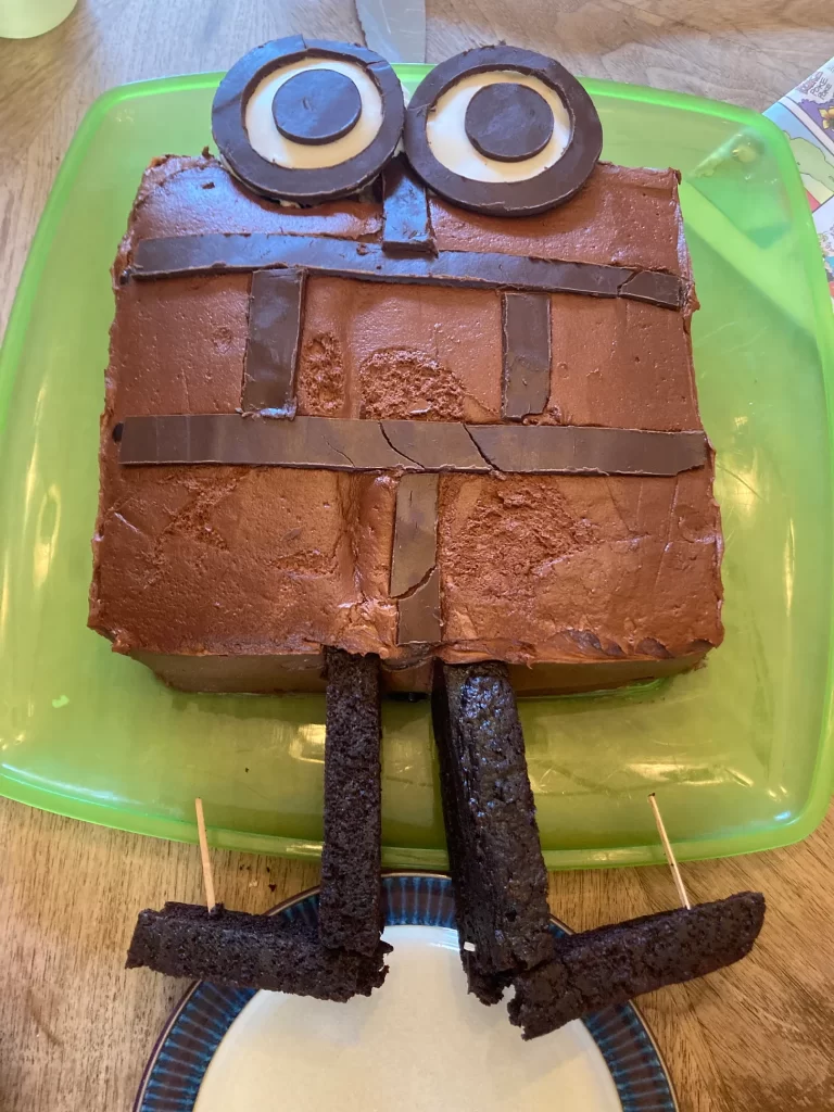 A cake in the shape of Patrick, a brick with eyes, hands and feet