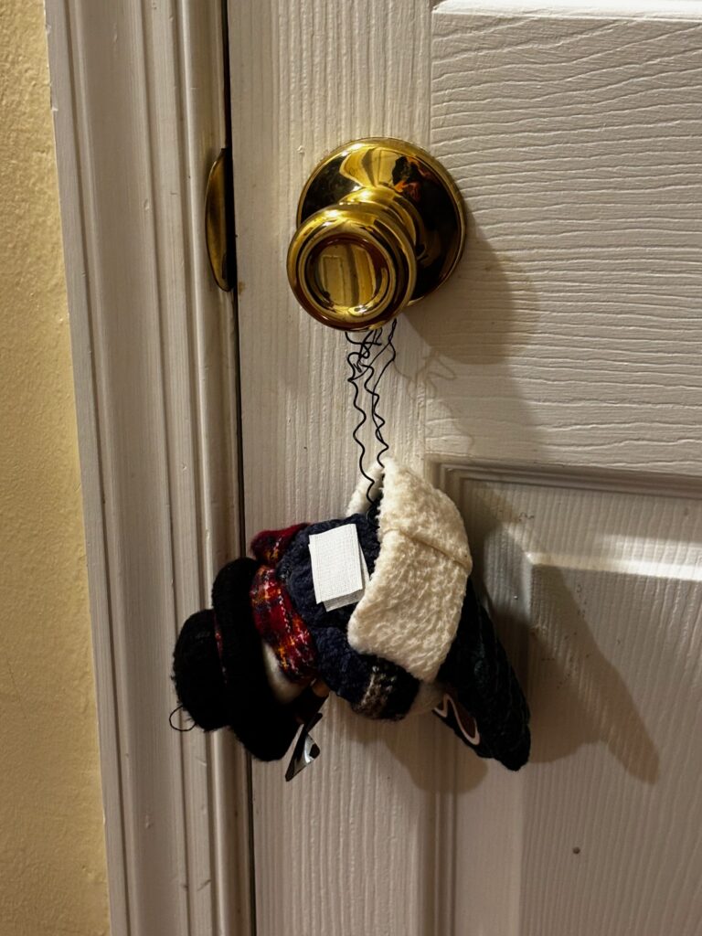 A snowman Christmas ornament hanging from a doorknob