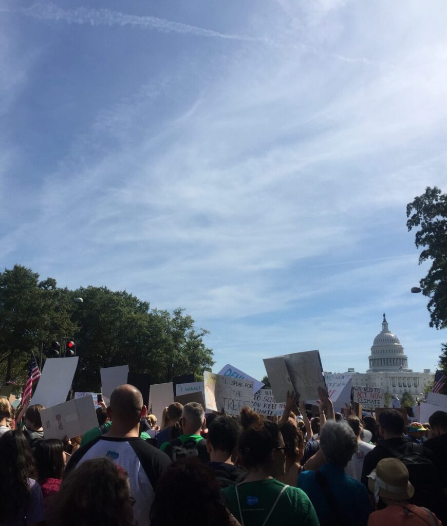 A group of protestors with climate signs marching to the U.S. Capital
